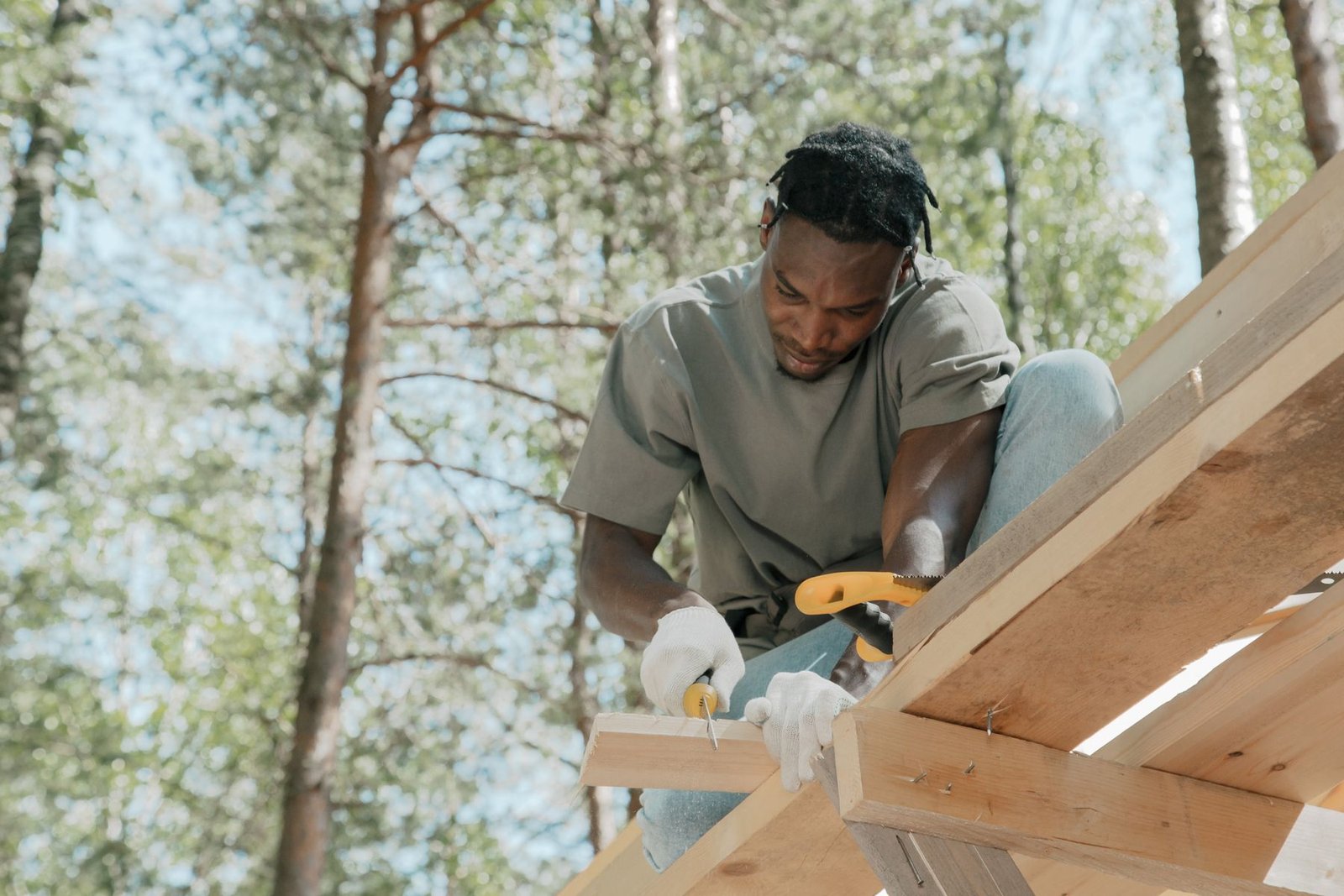 Carpenter assembling a timber frame outdoors