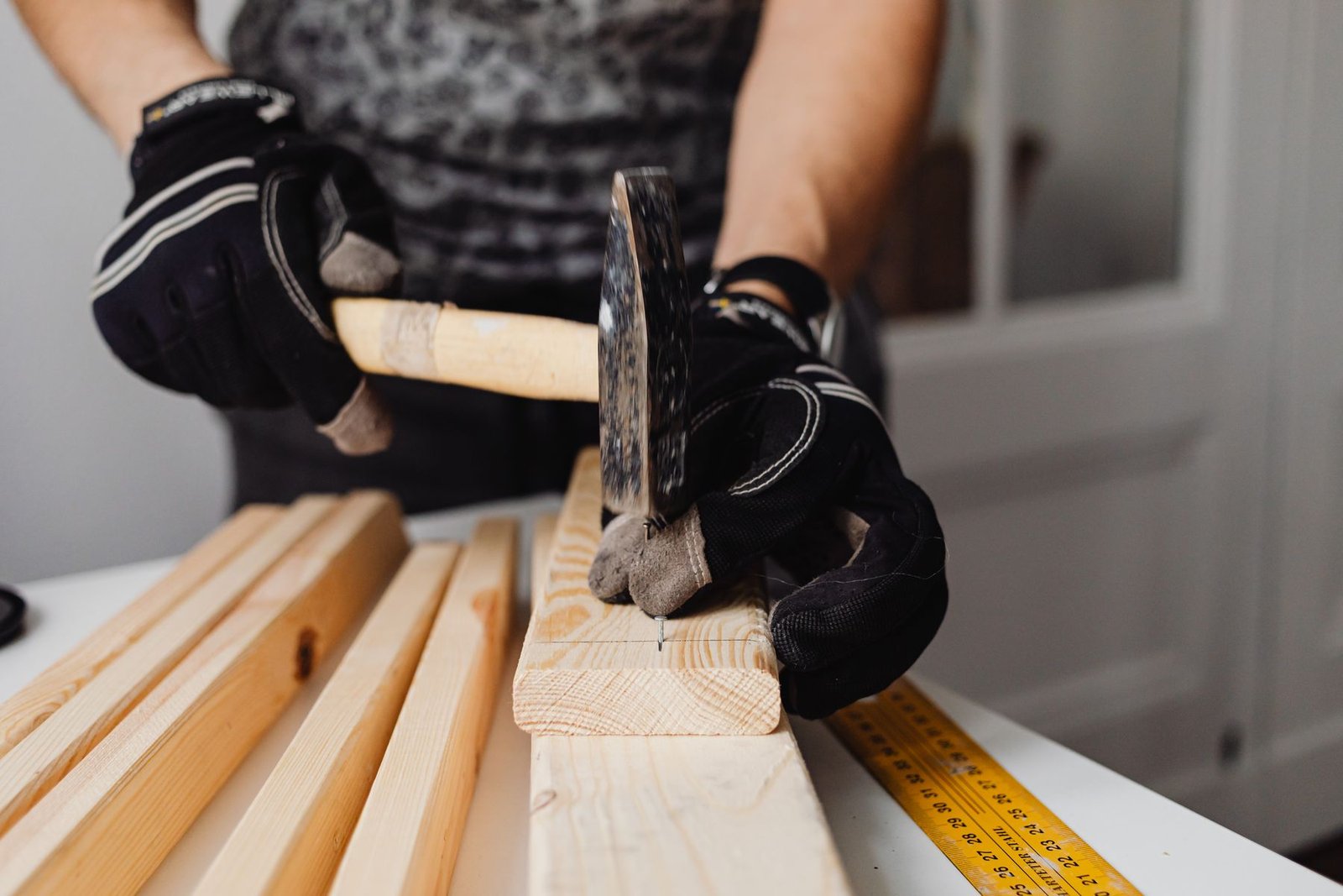 Craftsman driving nails into a timber board