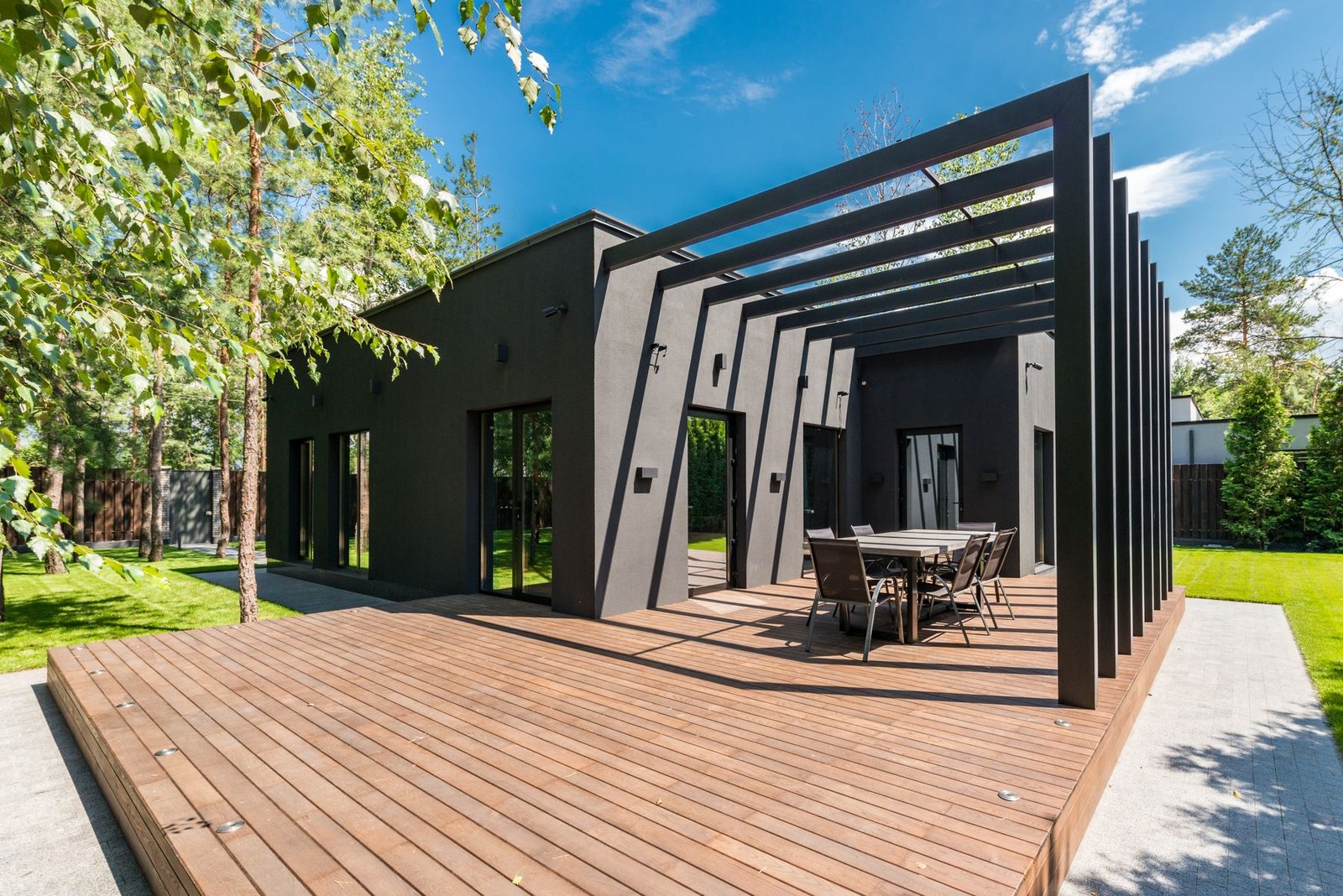 Wood deck with outdoor dining set surrounded by planting