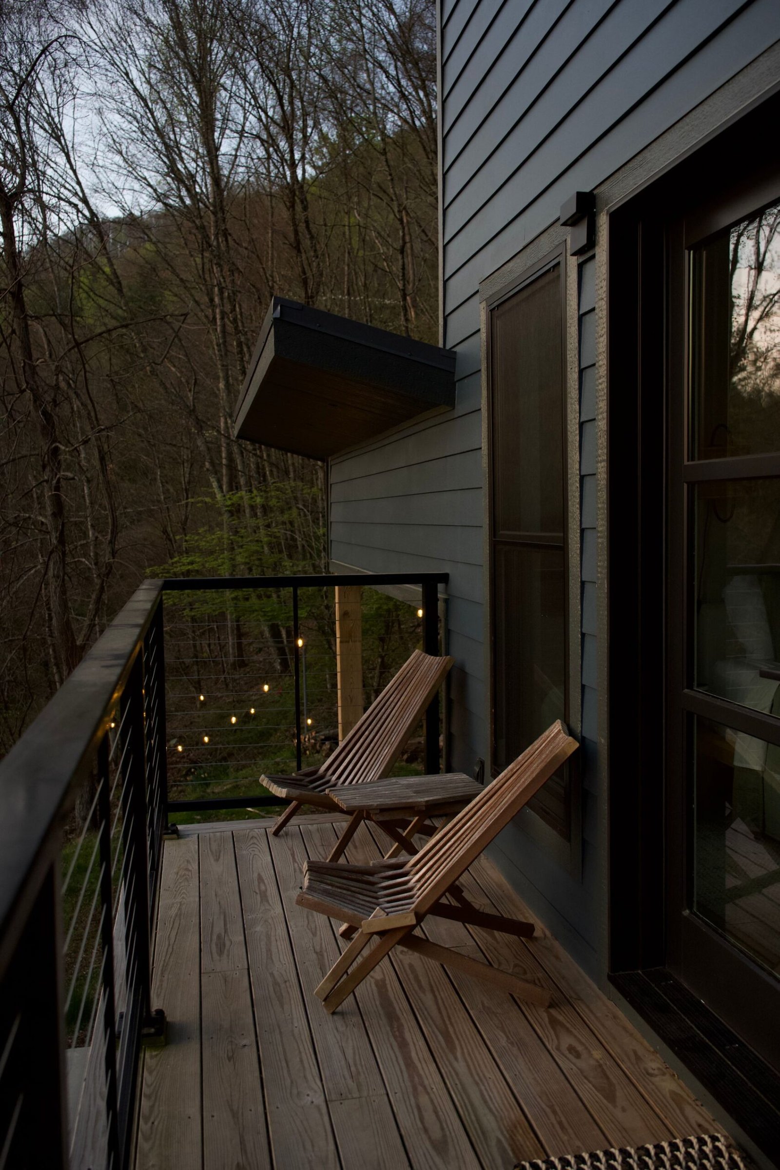 Wood deck with chairs at dusk backing onto trees