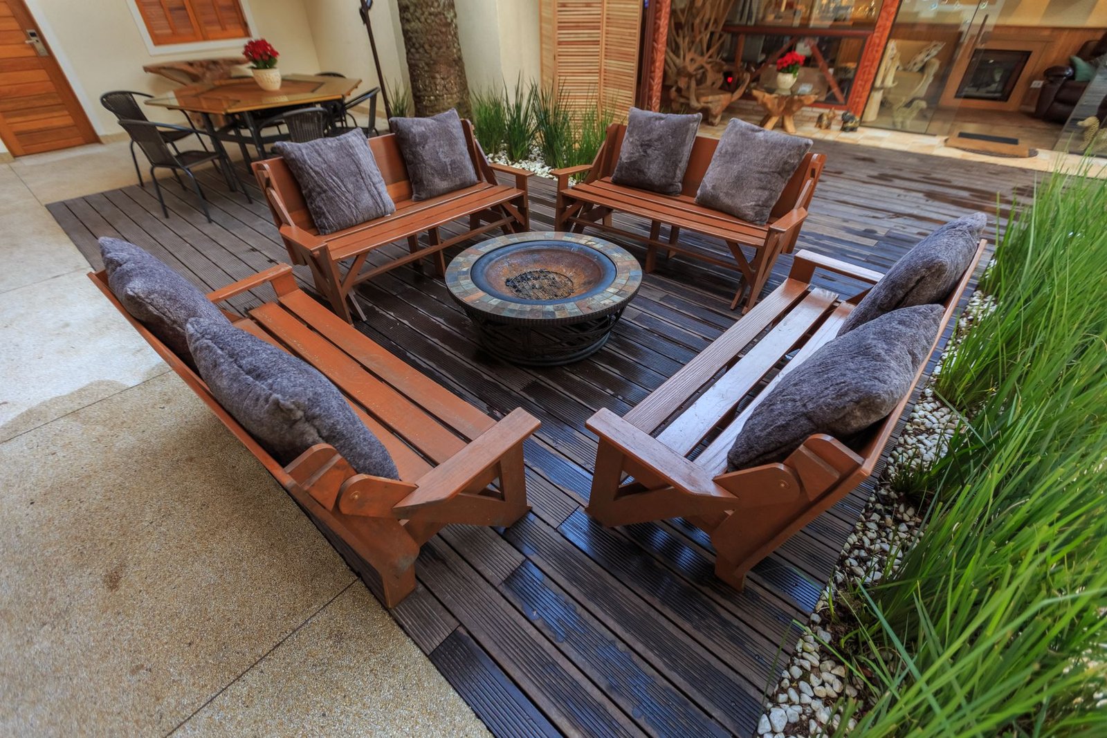 Outdoor deck lounge with bench seating around a fire pit