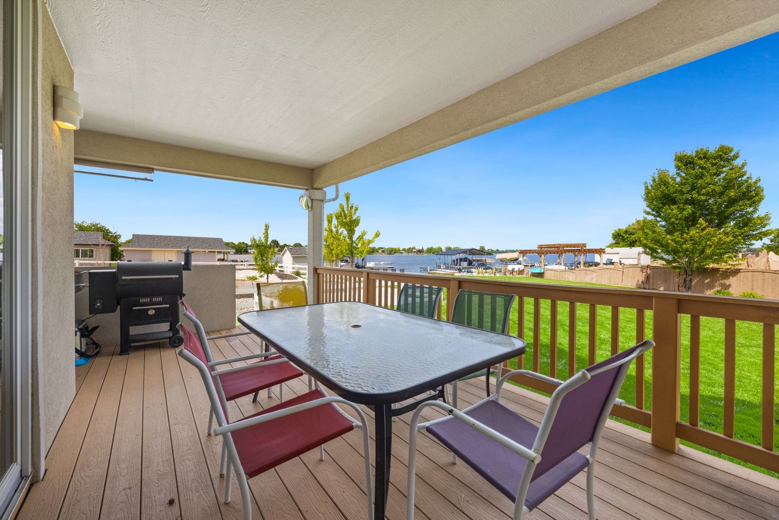 Deck with seating and a barbecue overlooking a lake
